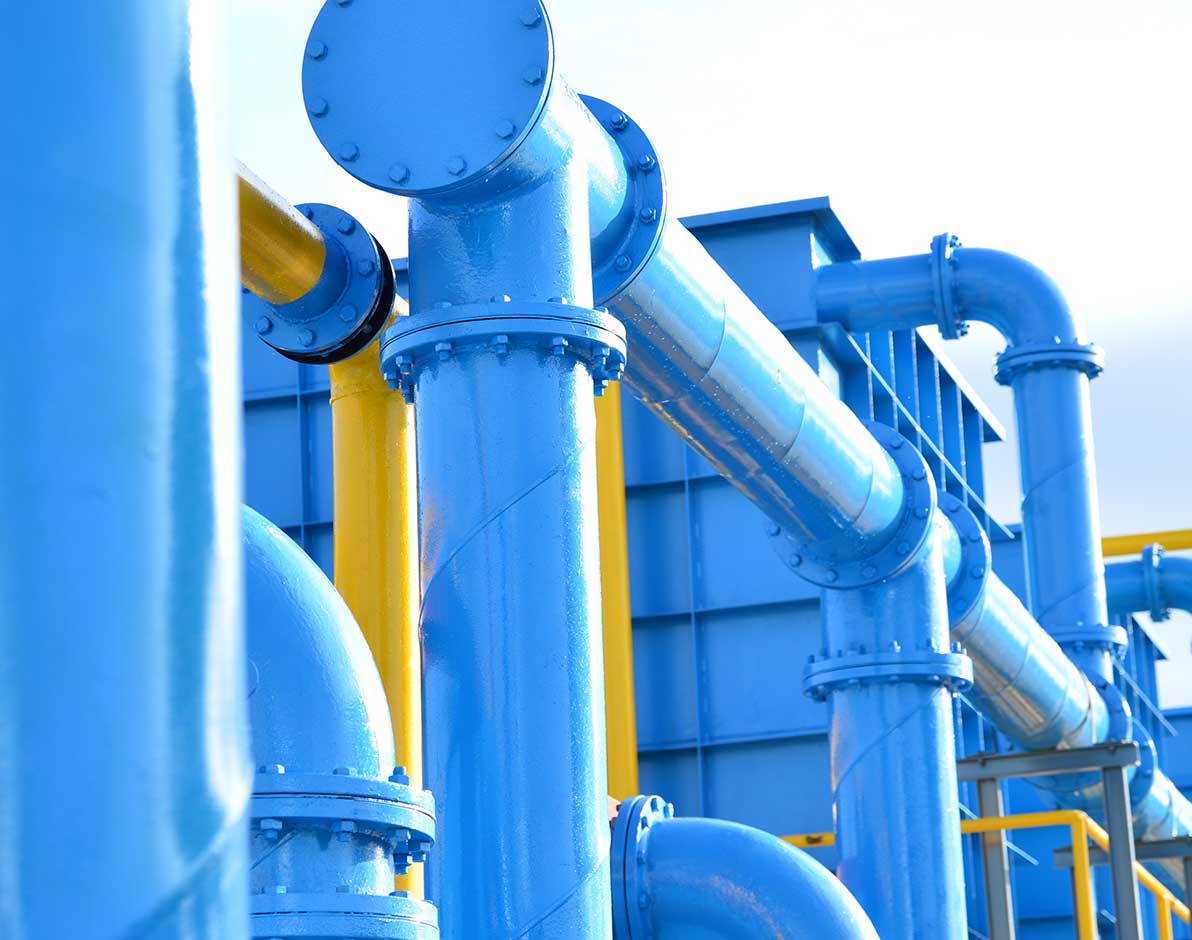 A modern water treatment plant with large, bright blue and yellow pipes.