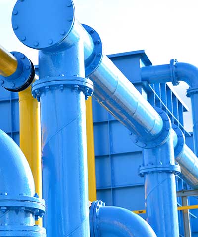 A modern water treatment plant with large, bright blue and yellow pipes.