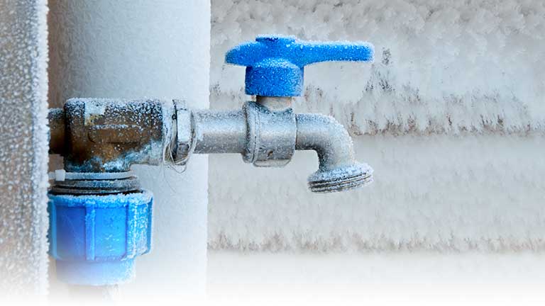A frost covered outdoor water tap.