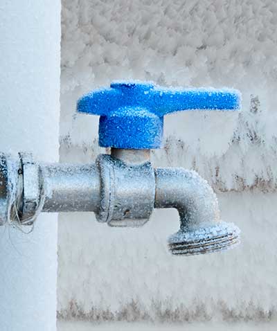 A frost covered outdoor water tap.