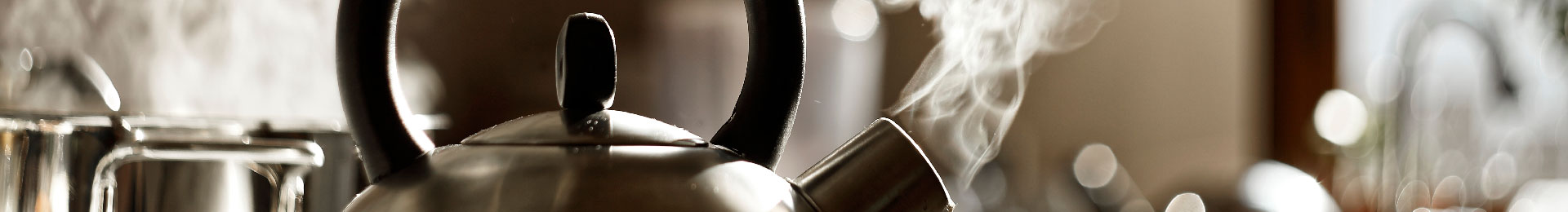 A boiling kettle releasing steam in a kitchen.