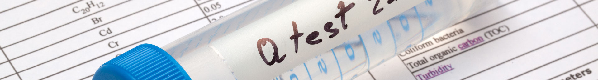 A testing vial of water sitting on a page of lab results.