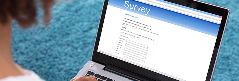 A woman completing LSL Survey on a laptop.